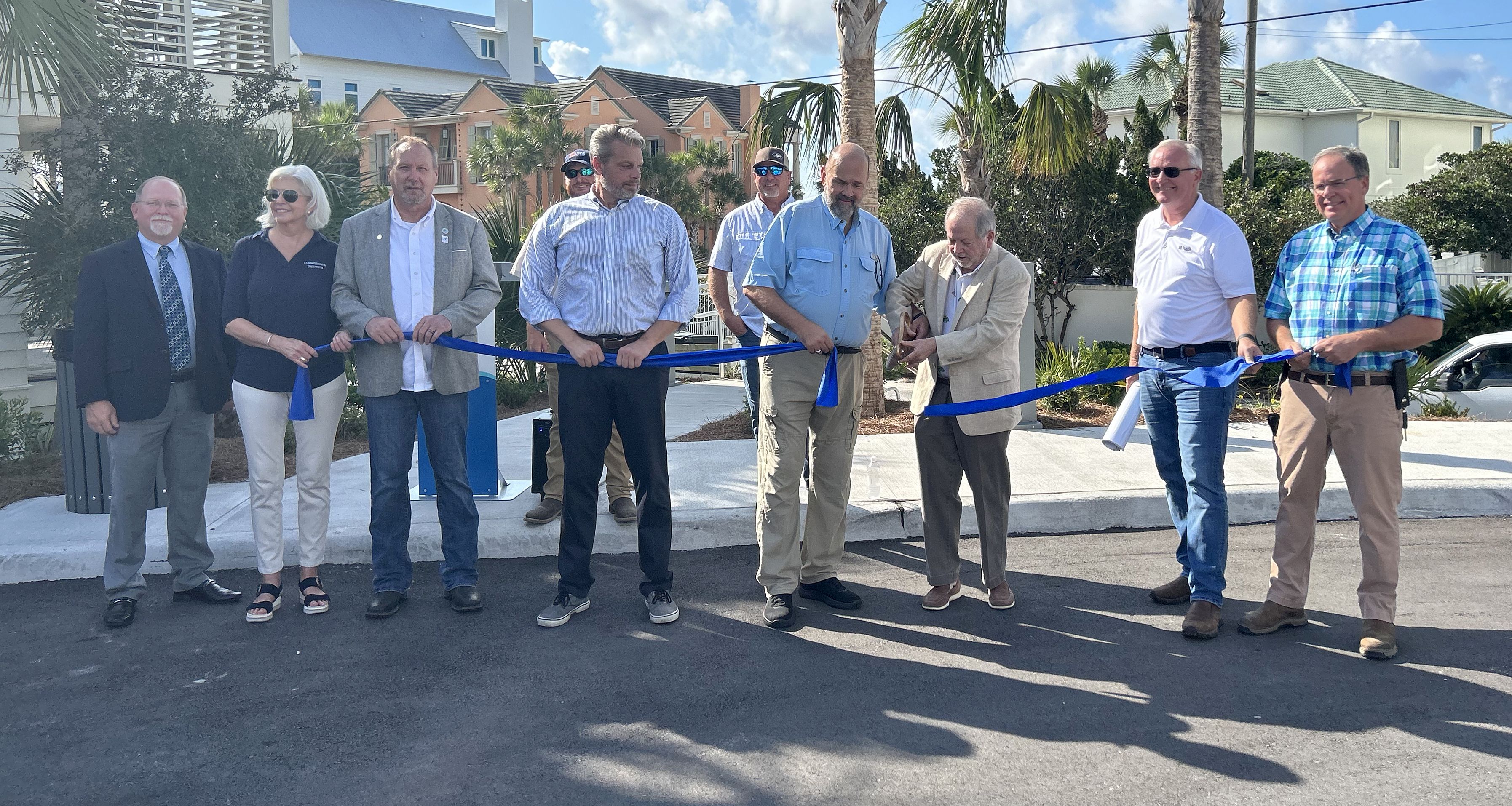Walton County District 2 commissioner Danny Glidewell assists Walton County District 5 Commissioner Tony Anderson with cutting the ribbon for the Eastern Lake Municipal Parking facility on Aug. 9, 2023.